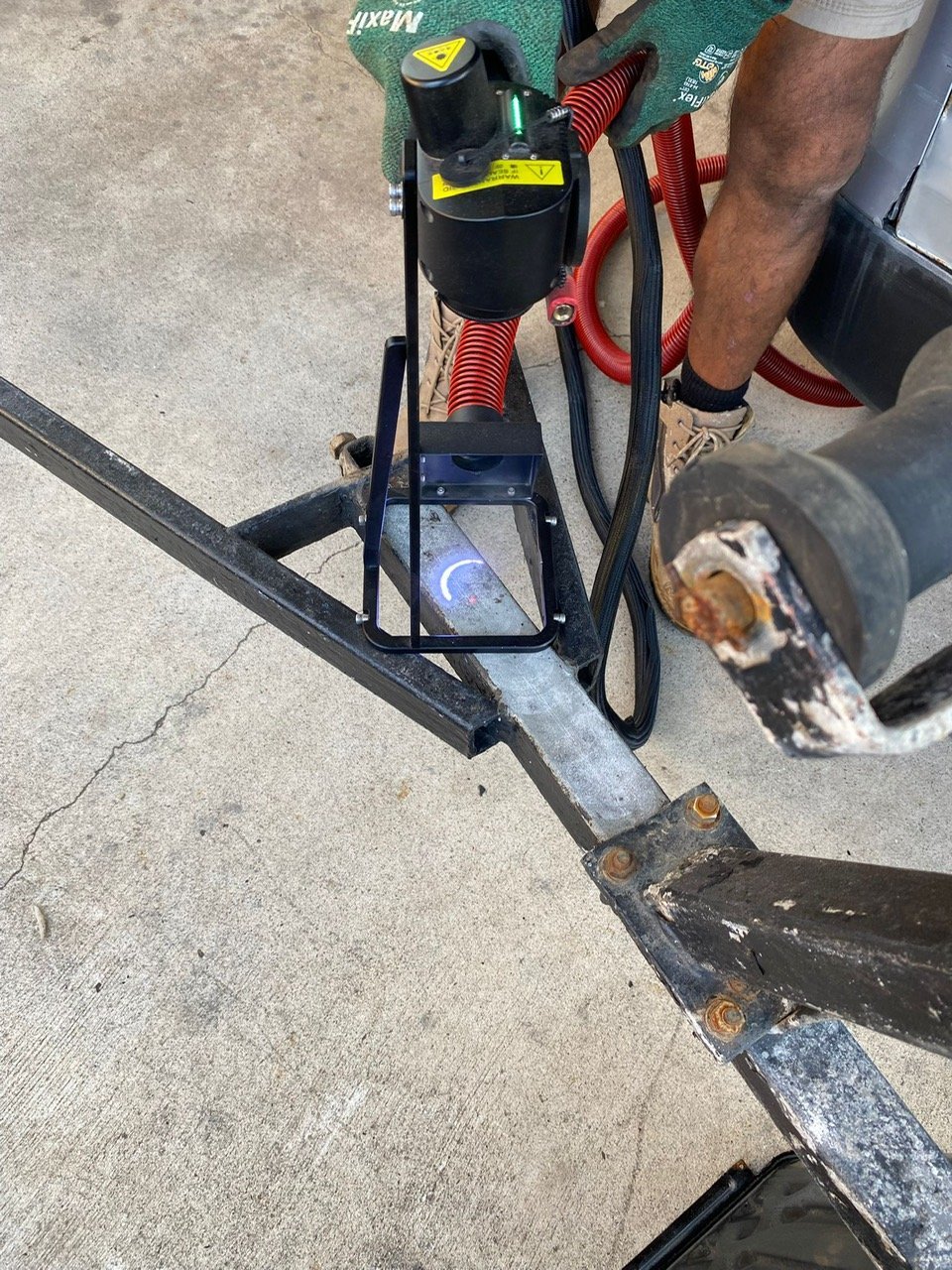 Vacuum hose capturing debris at the laser head